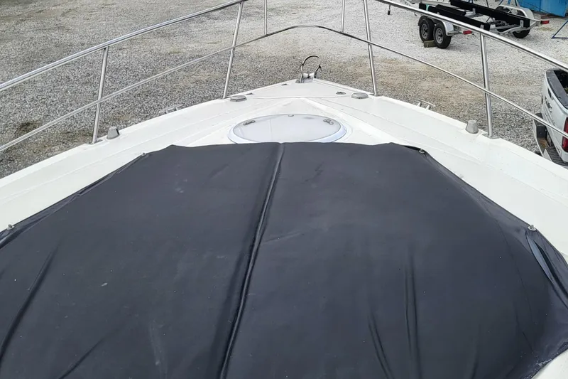 Slide: The Image of 2008 Cruisers 330 boat deck with black cover and railing, parked on gravel. - 6