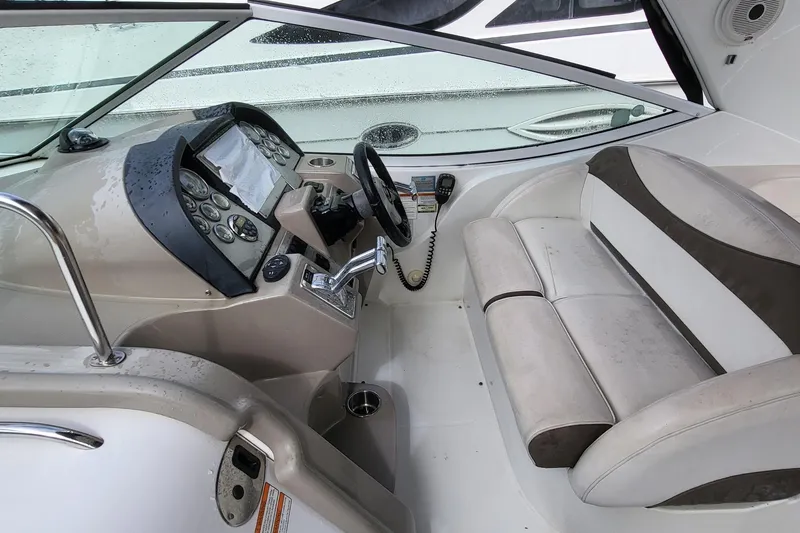 Slide: The Image of 2008 Cruisers 330 boat cockpit with steering wheel, control panel, and cushioned seating. - 9
