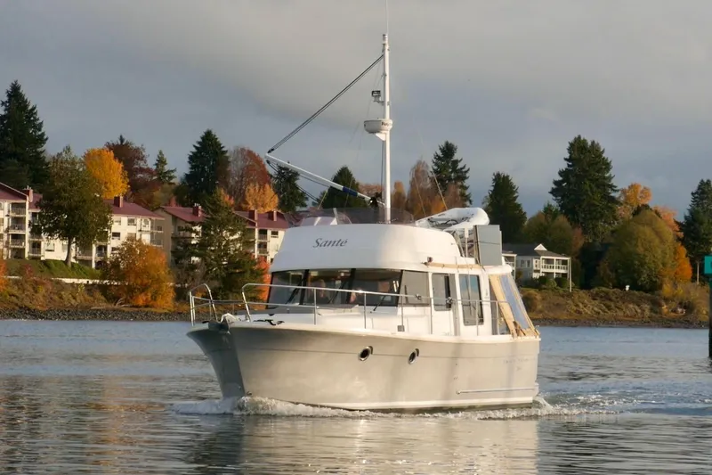 Slide: The Image of 2013 Beneteau Swift Trawler 34 Fly on serene lake with forested hills. - 2