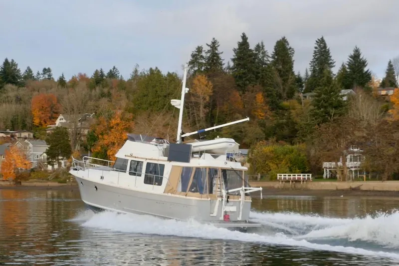 Slide: The Image of 2013 Beneteau Swift Trawler 34 Fly on serene lake with mountainous backdrop. - 3