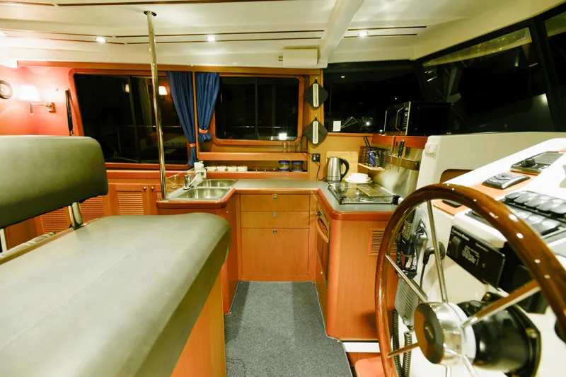 Slide: The Image of 2013 Beneteau Swift Trawler 34 Fly docked, featuring beige canvas covers and stainless steel railings. - 30