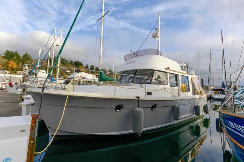 Slide: The Image of 2013 Beneteau Swift Trawler 34 Fly moored at a marina, surrounded by sailboats. - 5