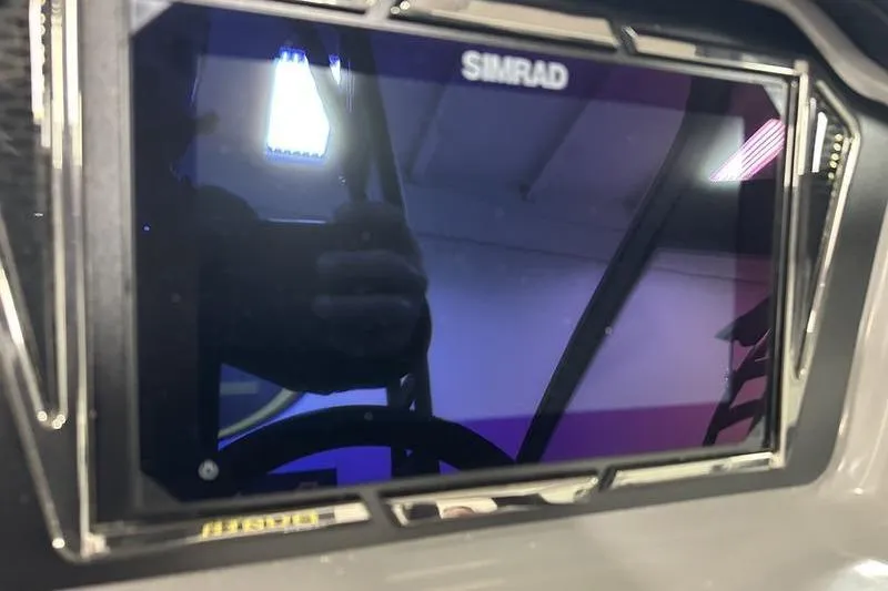Slide: The Image of Simrad display on 2026 Chaparral 21 SSi boat dashboard, reflecting interior lights. - 16