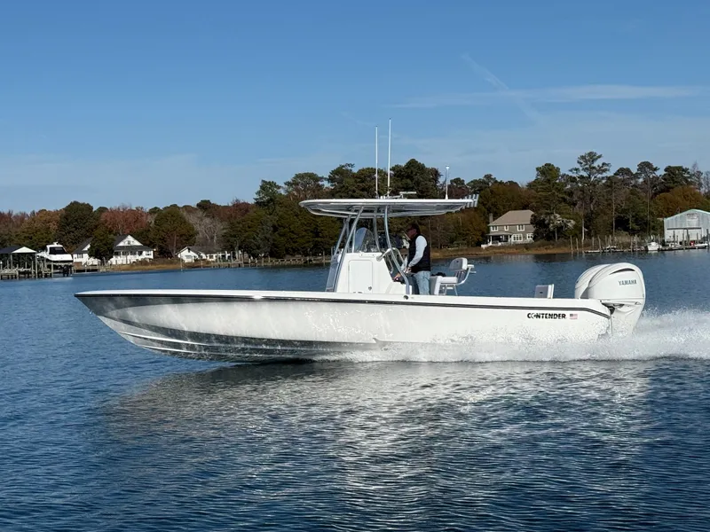 The Image of 2026 Contender 29 Bay boat cruising on a calm lake with scenic background. - 0