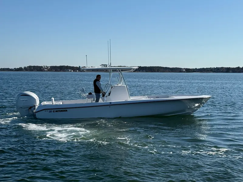 Slide: The Image of 2026 Contender 29 Bay boat cruising on calm waters under clear blue sky. - 6