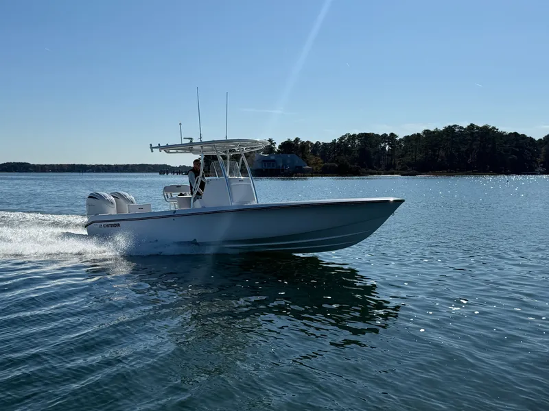 Slide: The Image of 2026 Contender 29 Bay boat cruising on a sunny lake with trees in the background. - 8