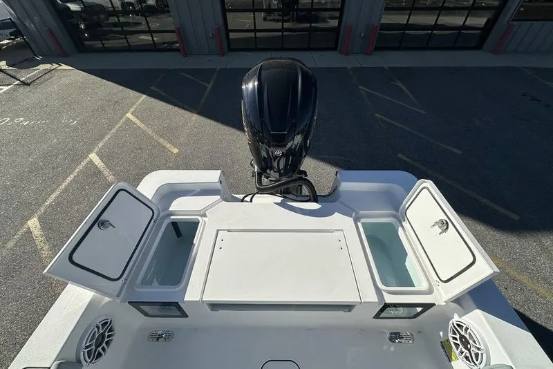 Slide: The Image of 2026 Sportsman Masters 227 Bay Boat with open storage compartments and outboard motor. - 14