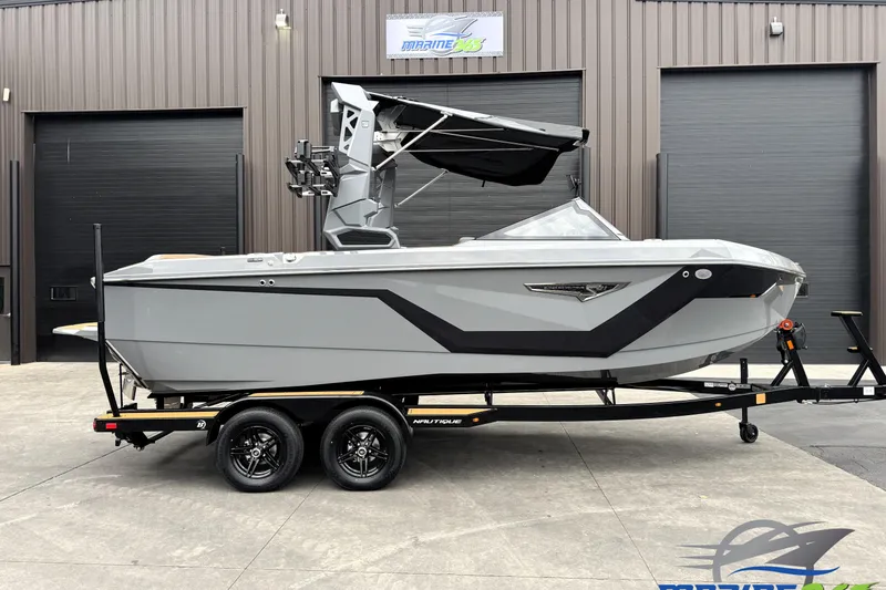 The Image of 2026 Nautique Super Air Nautique S21 boat on trailer, sleek gray design. - 0