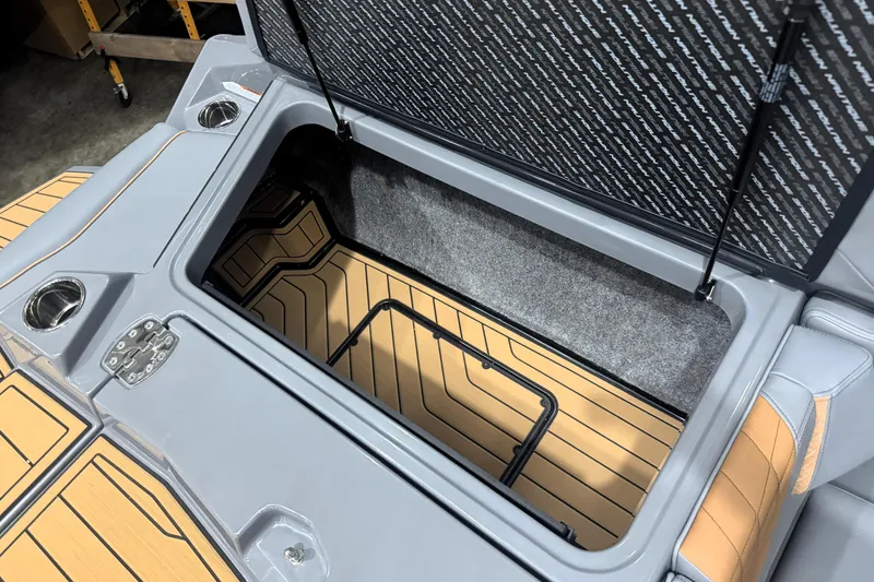 Slide: The Image of 2026 Nautique Super Air Nautique S21 storage compartment with sleek design and cup holders. - 13