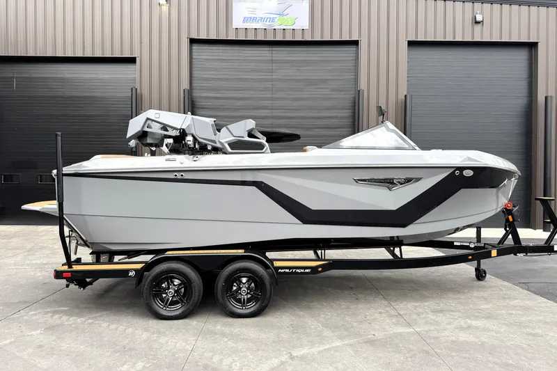 Slide: The Image of 2026 Nautique Super Air Nautique S21 boat on trailer, sleek design, parked outdoors. - 2