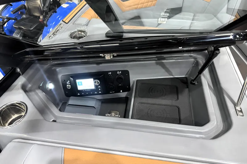 Slide: The Image of 2026 Nautique Super Air Nautique S21 dashboard with audio controls and storage compartment. - 20