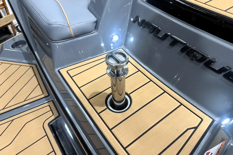Slide: The Image of 2026 Nautique Super Air Nautique S21 boat interior with teak flooring and chrome details. - 26