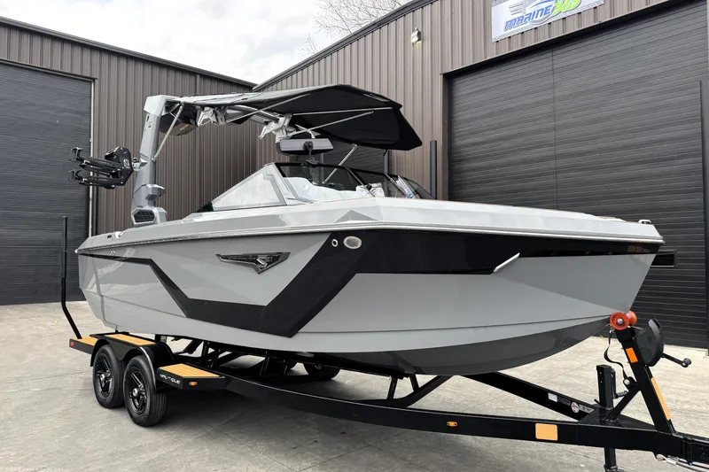 Slide: The Image of 2026 Nautique Super Air Nautique S21 boat on trailer, parked outside a warehouse. - 3