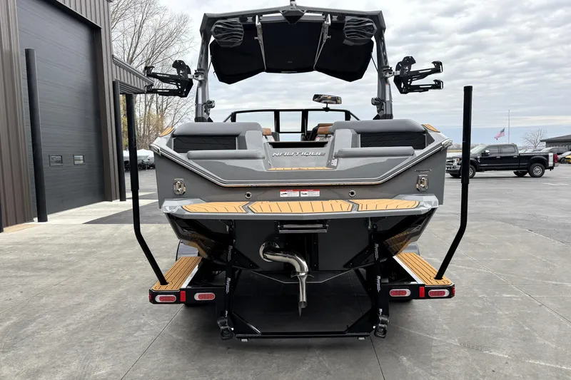 Slide: The Image of 2026 Nautique Super Air Nautique S21 boat, rear view, parked outdoors. - 6