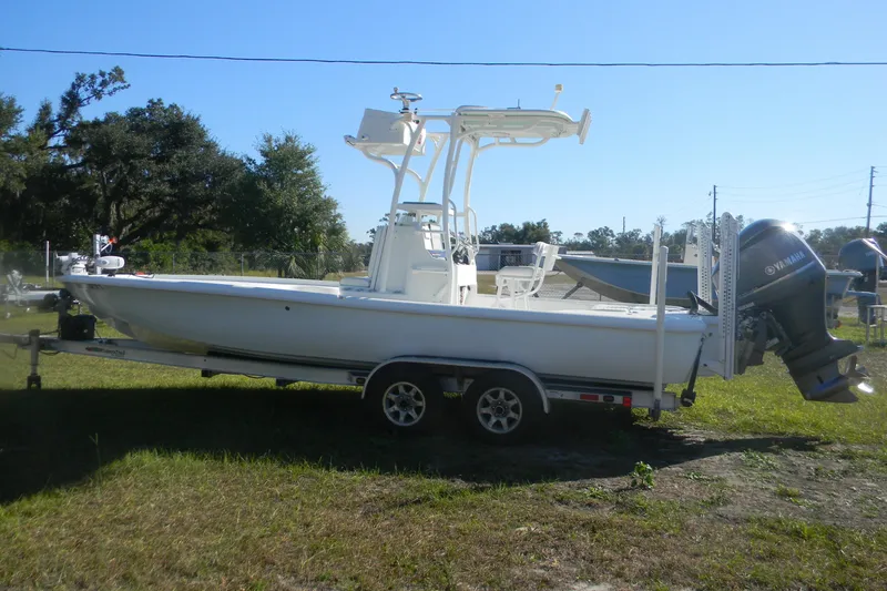 Slide: The Image of 2015 Yellowfin 24 Bay boat interior with white cushioned seating and motor. - 13