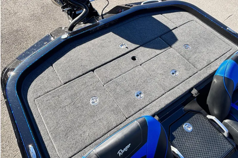 Slide: The Image of 2026 Ranger Z521 boat deck with storage compartments and blue-accented seats. - 13