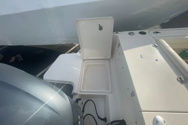 Slide: The Image of 2018 Grady-White Freedom 235 boat deck with open storage compartment and engine view. - 20