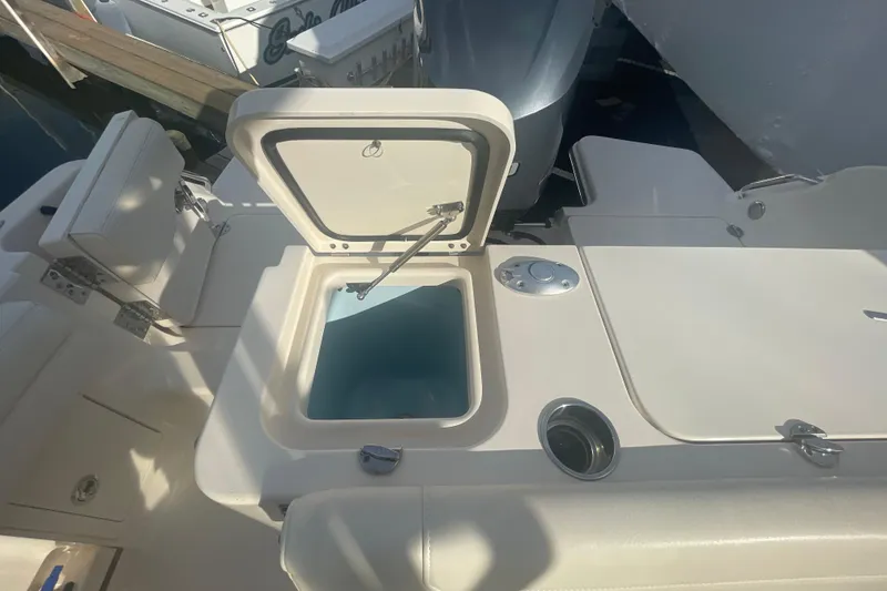 Slide: The Image of 2018 Grady-White Freedom 235 boat with open storage compartment and seating area. - 26