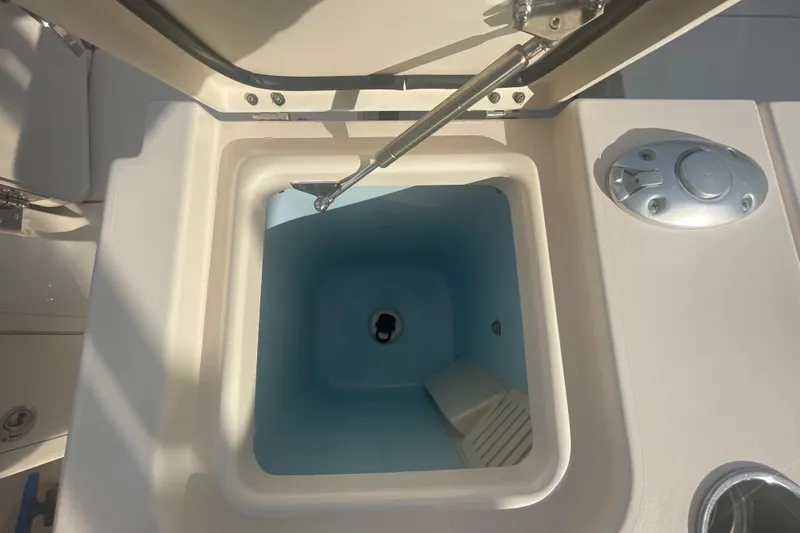 Slide: The Image of Open storage compartment on 2018 Grady-White Freedom 235 boat, featuring a hydraulic lift. - 27