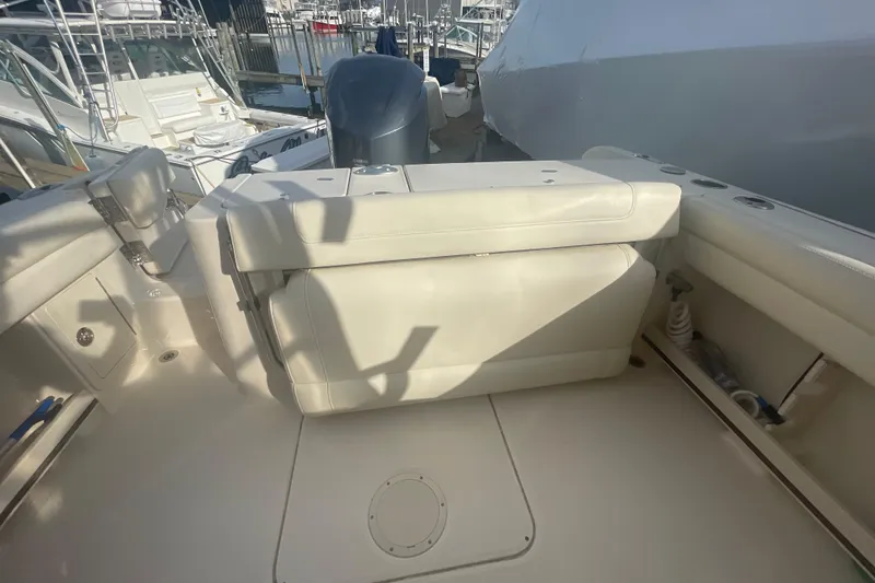Slide: The Image of 2018 Grady-White Freedom 235 boat interior with seating and engine view at marina. - 33