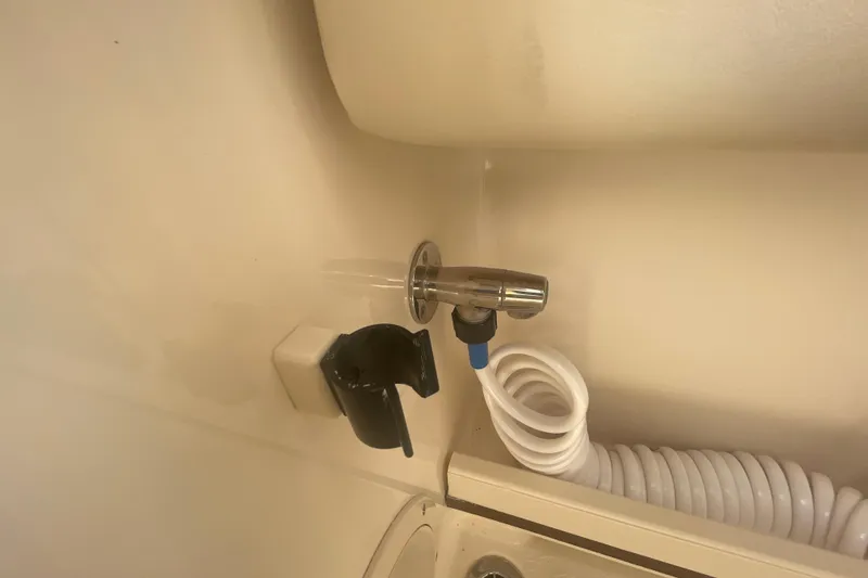 Slide: The Image of 2018 Grady-White Freedom 235 boat interior with coiled hose and faucet. - 39