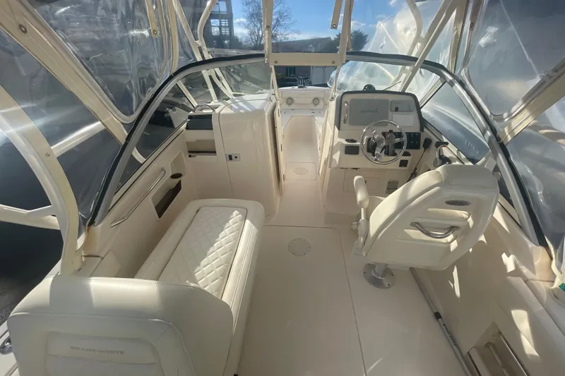 Slide: The Image of 2018 Grady-White Freedom 235 boat interior with helm, seating, and clear canopy. - 40