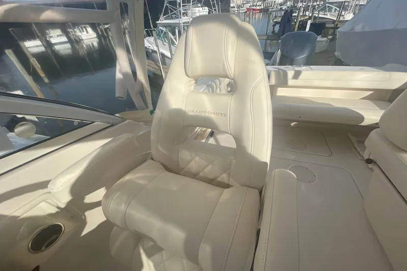 Slide: The Image of 2018 Grady-White Freedom 235 boat interior with luxurious seating at a marina. - 43