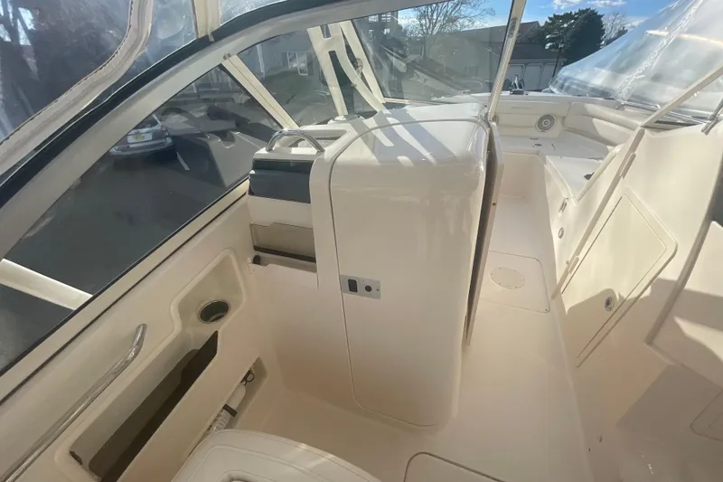 Slide: The Image of 2018 Grady-White Freedom 235 boat interior, featuring helm and seating area with clear canopy. - 45
