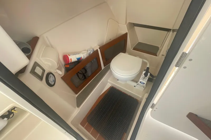 Slide: The Image of 2018 Grady-White Freedom 235 boat interior with compact marine toilet and storage. - 49