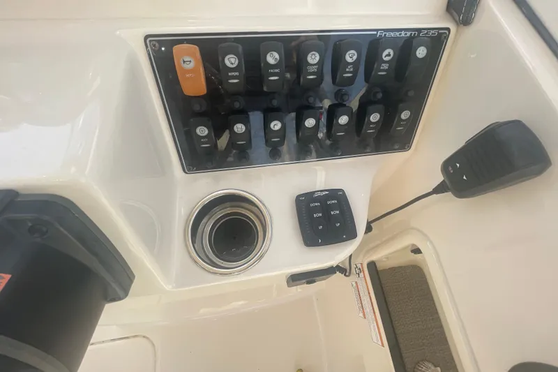 Slide: The Image of Control panel of 2018 Grady-White Freedom 235 boat with switches and microphone. - 56