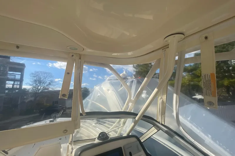 Slide: The Image of Interior view of 2018 Grady-White Freedom 235 boat with clear canopy and dashboard. - 63
