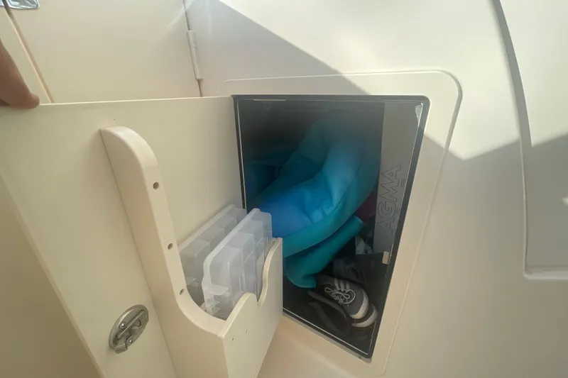 Slide: The Image of Storage compartment on a 2018 Grady-White Freedom 235 boat, containing gear and accessories. - 68