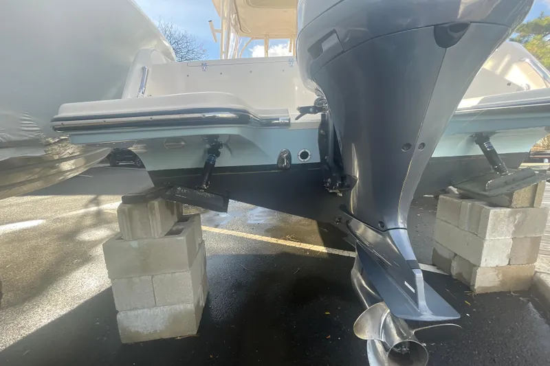 Slide: The Image of 2018 Grady-White Freedom 235 boat on blocks, showcasing outboard motor and hull. - 7