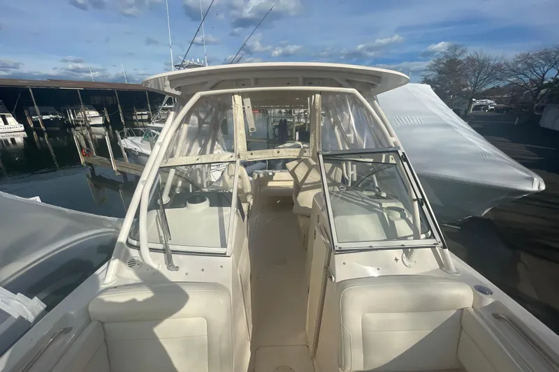 Slide: The Image of 2018 Grady-White Freedom 235 boat interior with seating and windshield, docked at marina. - 74