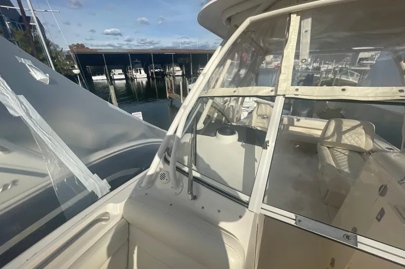 Slide: The Image of 2018 Grady-White Freedom 235 boat interior with clear enclosure, docked at marina. - 81