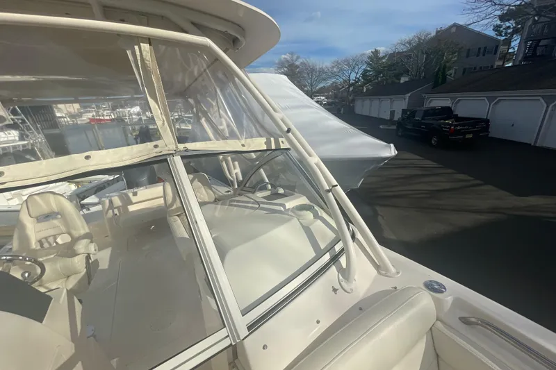 Slide: The Image of 2018 Grady-White Freedom 235 boat with clear windshield and beige interior, parked outdoors. - 82