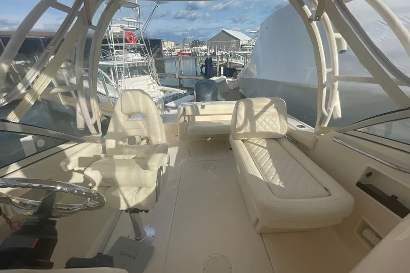 Slide: The Image of 2018 Grady-White Freedom 235 boat interior with seating and steering wheel at marina. - 83