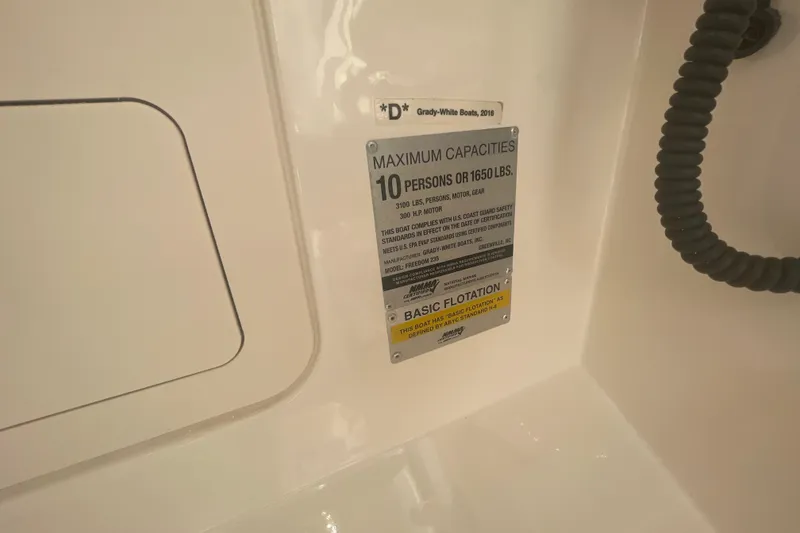 Slide: The Image of Capacity label on 2018 Grady-White Freedom 235 boat, indicating 10-person or 1650 lbs limit. - 86