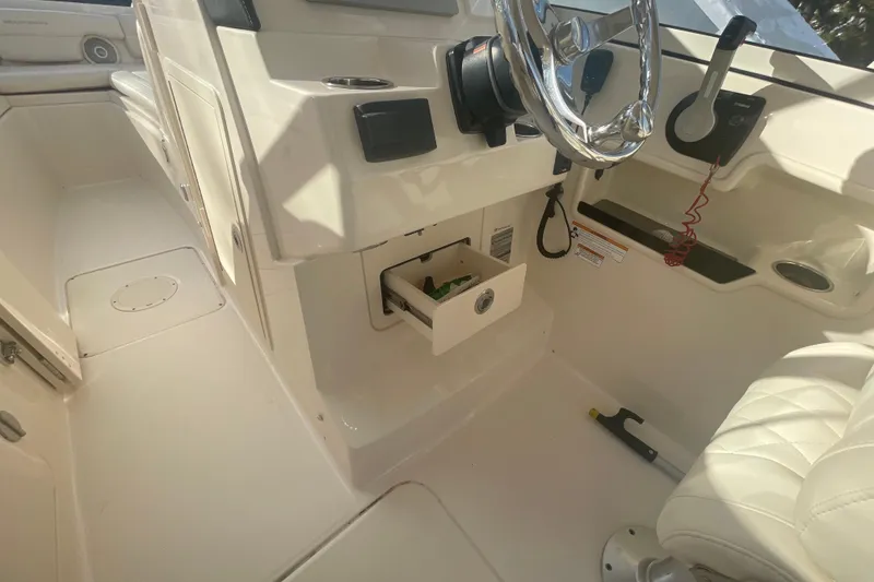 Slide: The Image of 2018 Grady-White Freedom 235 boat interior with steering wheel and storage compartment. - 88