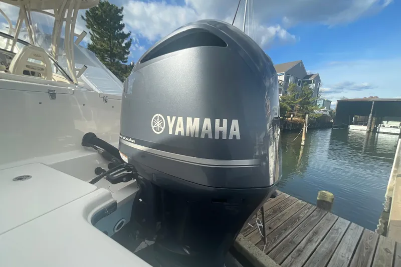 Slide: The Image of 2018 Grady-White Freedom 235 boat with Yamaha outboard motor docked by the water. - 95