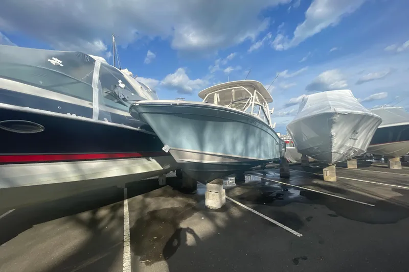 Slide: The Image of 2018 Grady-White Freedom 235 boat in storage, surrounded by other covered boats. - 96