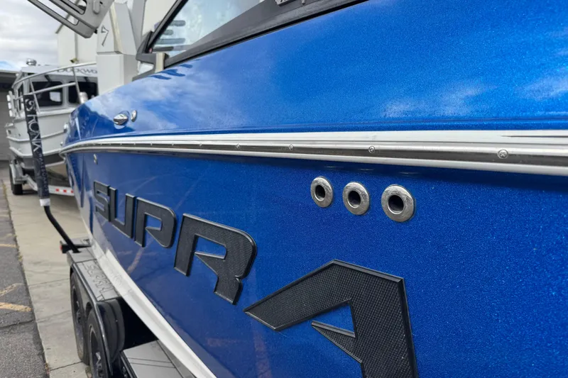Slide: The Image of Blue 2020 Supra SL 575 boat side view with logo and chrome accents. - 11