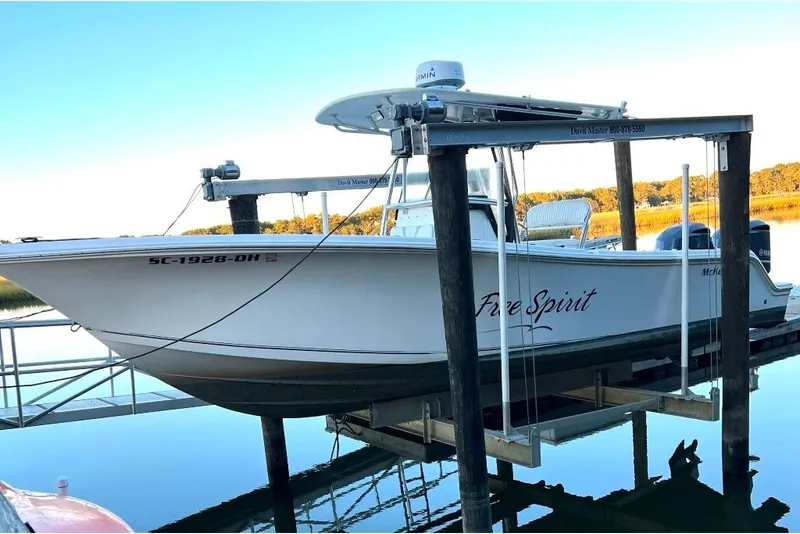 Slide: The Image of 2008 McKee Craft Freedom 28 FS/CC boat named "Free Spirit" on a lift by the water. - 5