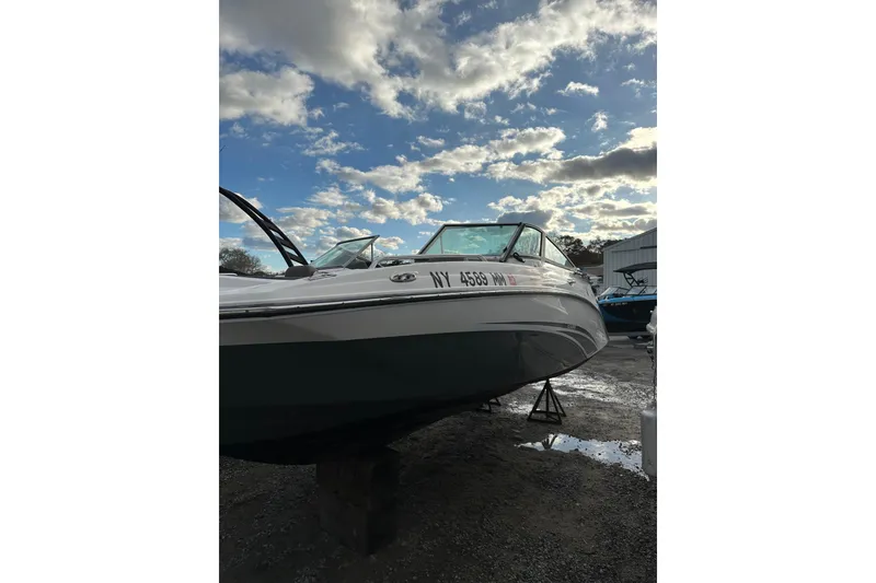 The Image of 2016 Yamaha Boats 212SS on dry dock under a partly cloudy sky. - 1