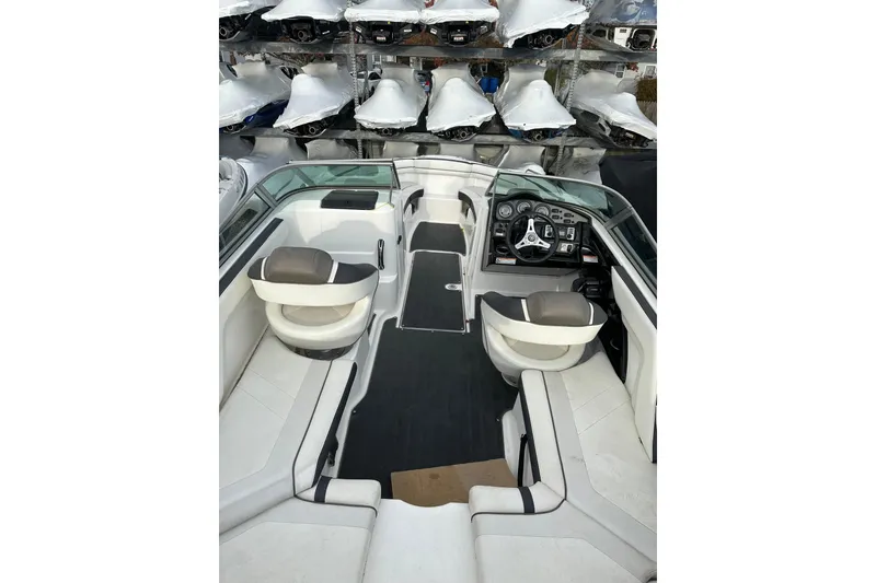 Slide: The Image of 2016 Yamaha Boats 212SS interior with seating and dashboard, surrounded by covered boats. - 12