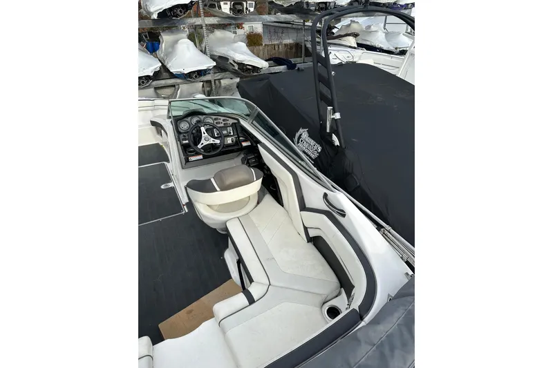 Slide: The Image of 2016 Yamaha Boats 212SS interior with steering wheel and seating, covered in black tarp. - 14