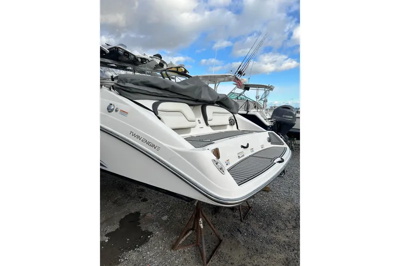 Slide: The Image of 2016 Yamaha Boats 212SS with twin engines, docked on gravel under a cloudy sky. - 2