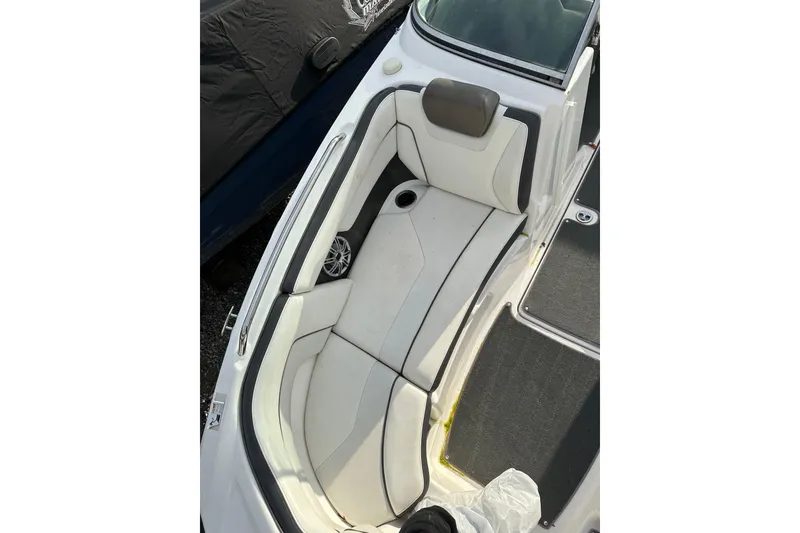 Slide: The Image of 2016 Yamaha Boats 212SS interior seating with white upholstery and cup holder. - 25