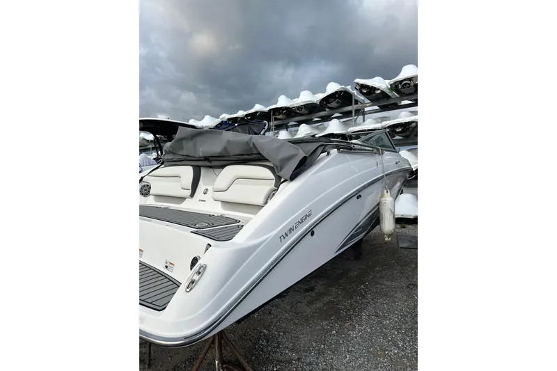 Slide: The Image of 2016 Yamaha Boats 212SS, white, twin engine, docked with cover, under cloudy sky. - 3