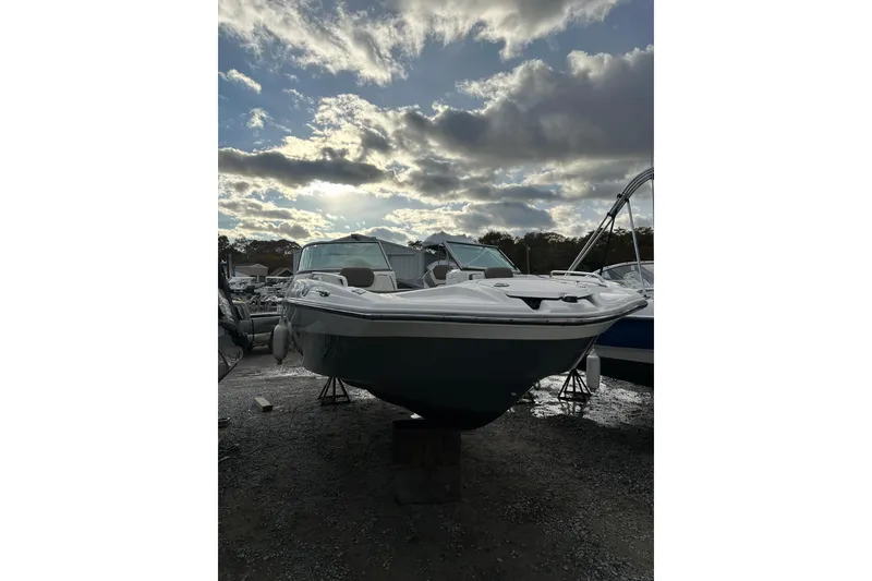 Slide: The Image of 2016 Yamaha Boats 212SS under cloudy sky, parked on gravel. - 7